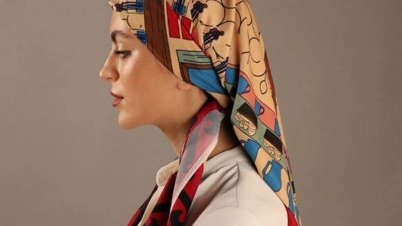 Yolkkh con i disegni stampati sui foulard che raccontano la storia di rifugiati della sua