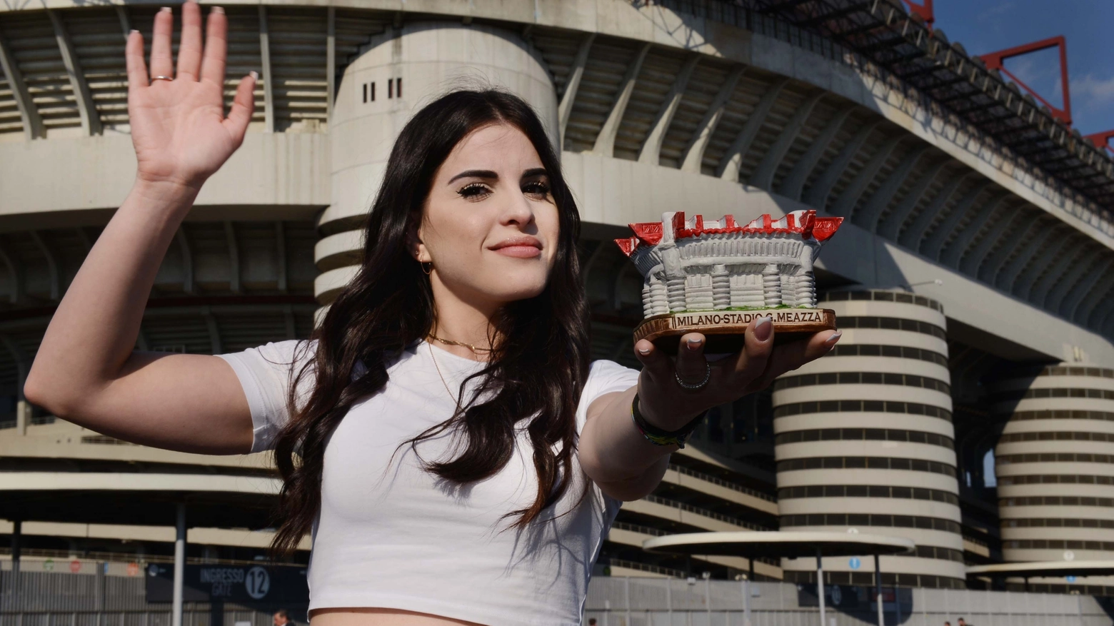 Una tifosa con in mano un gadget di San Siro, davanti allo stadio vero Una tifosa con in mano un gadget di San Siro, davanti allo stadio vero