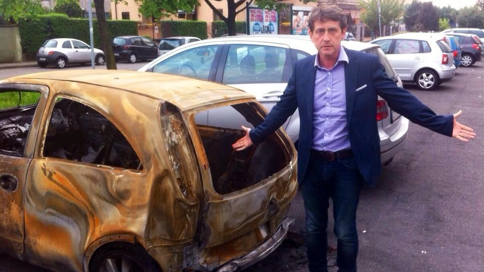 Il sindaco Angelo Rocchi davanti alla carcassa dell'auto bruciata