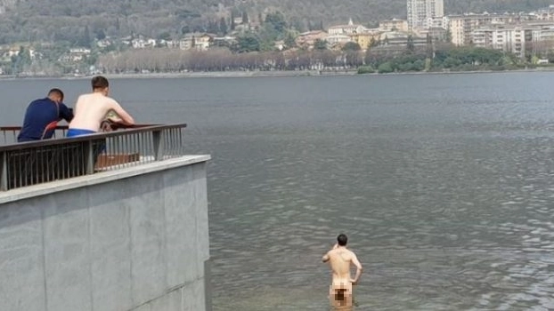 L'uomo nudo fa il bagno nelle acque del lago antistanti Malgrate