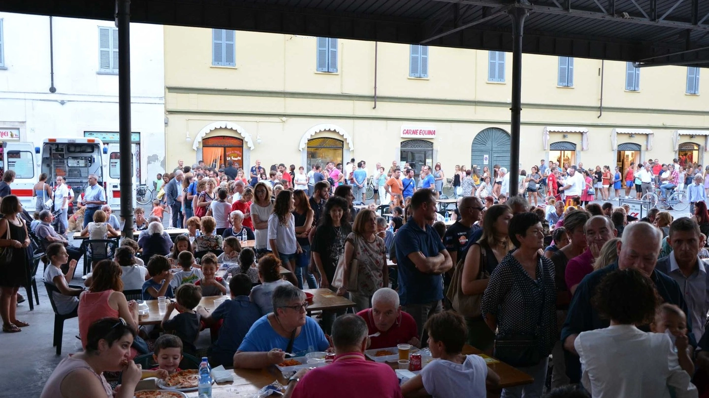 Gente ai tavoli e in coda sotto il mercato Coperto (Gazzola)