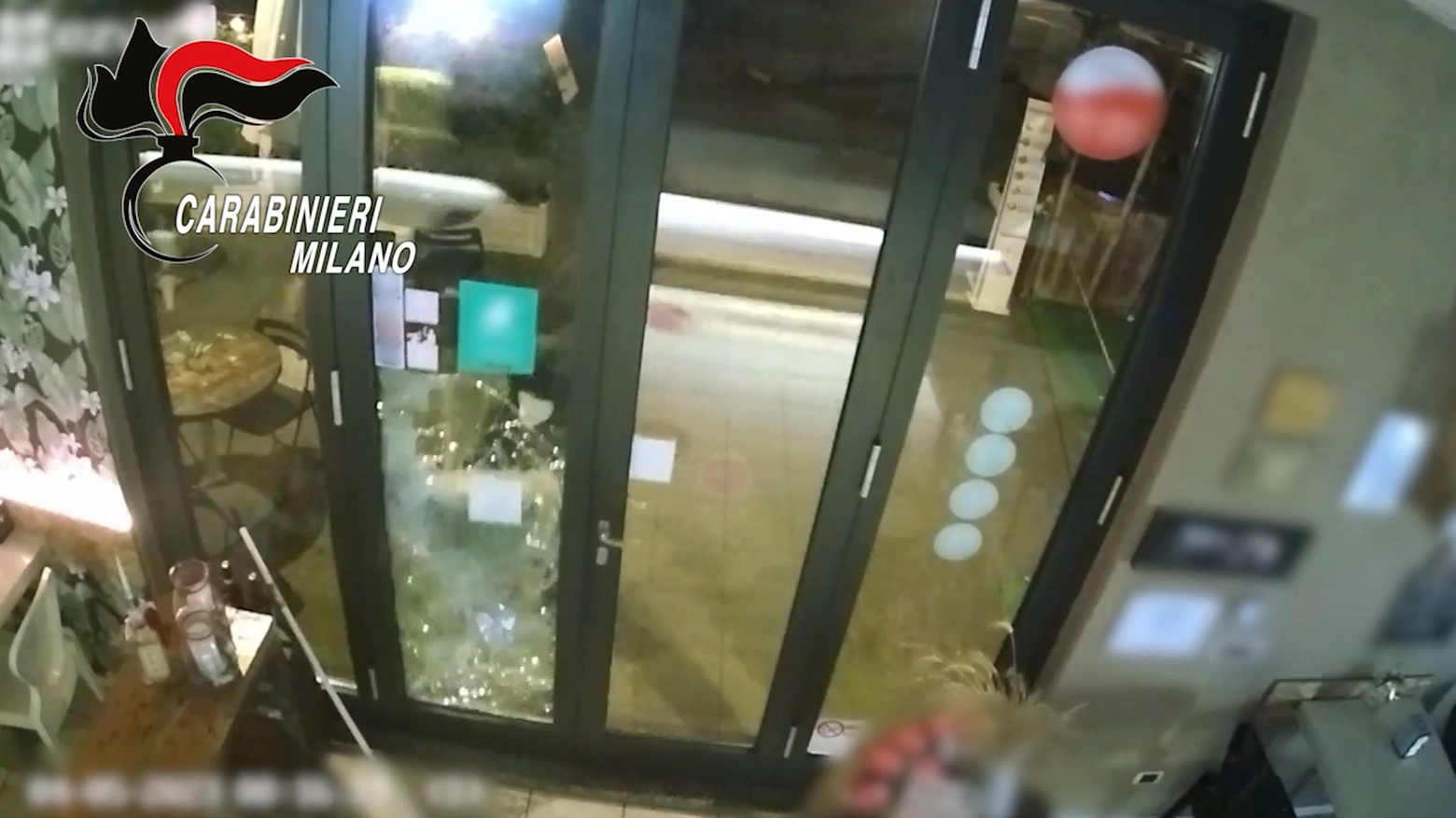 Il ladro che spacca la porta a vetri per intrufolarsi all'interno del locale
