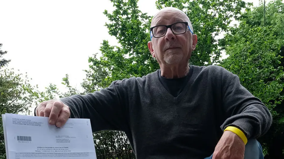 Claudio Trenta, 72, anni davanti alla buca che ha chiuso, mostra il maxi-verbale