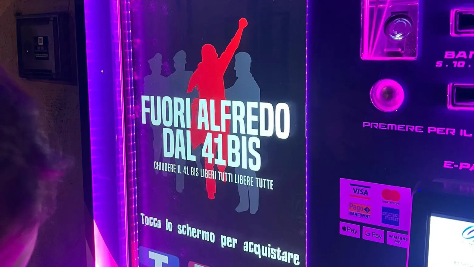Scritta per Cospito sullo schermo del distributore di sigarette