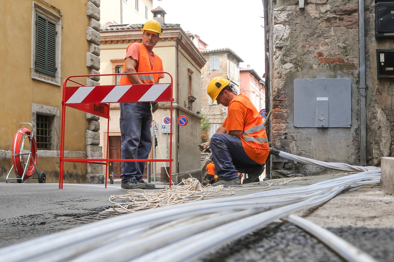 operai al lavoro per passare nei pozzetti i nuovi cavi necessari per garantire la banda ultra larga