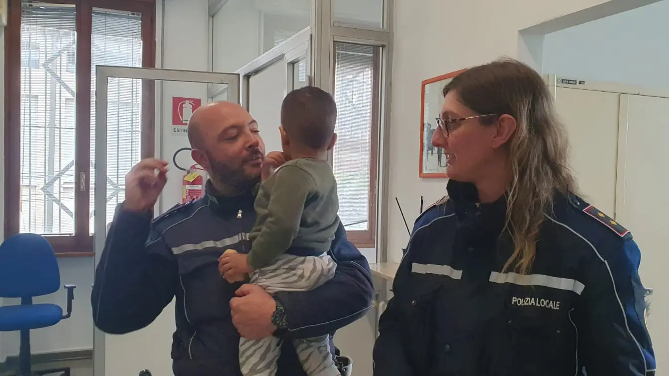 Il bimbo al sicuro tra le braccia degli agenti Il bimbo al sicuro tra le braccia degli agenti
