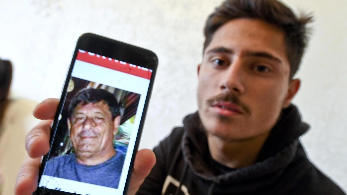 Un figlio di Raffaele Russo mostra la foto del padre, scomparso in Messico (Ansa)