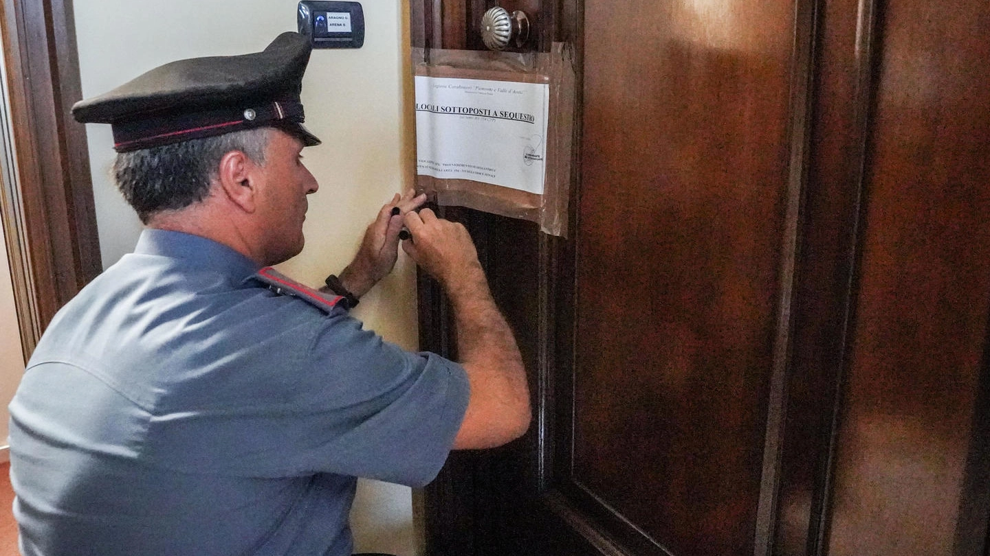 I carabinieri mettono i sigilli sulla porta dell'appartamento della coppia