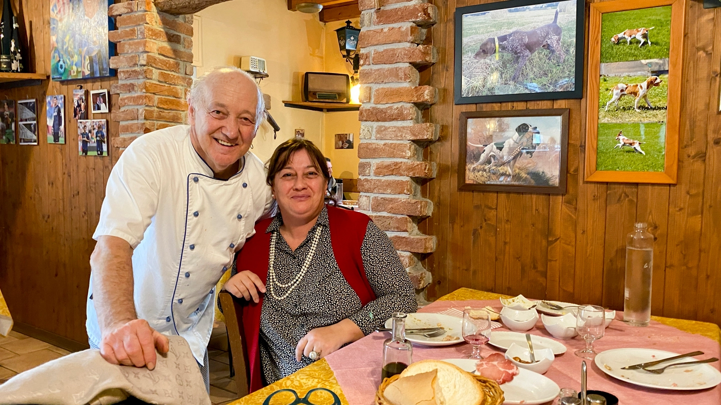 Mario Cattaneo, 69 anni, con una cliente tra i tavoli del suo locale