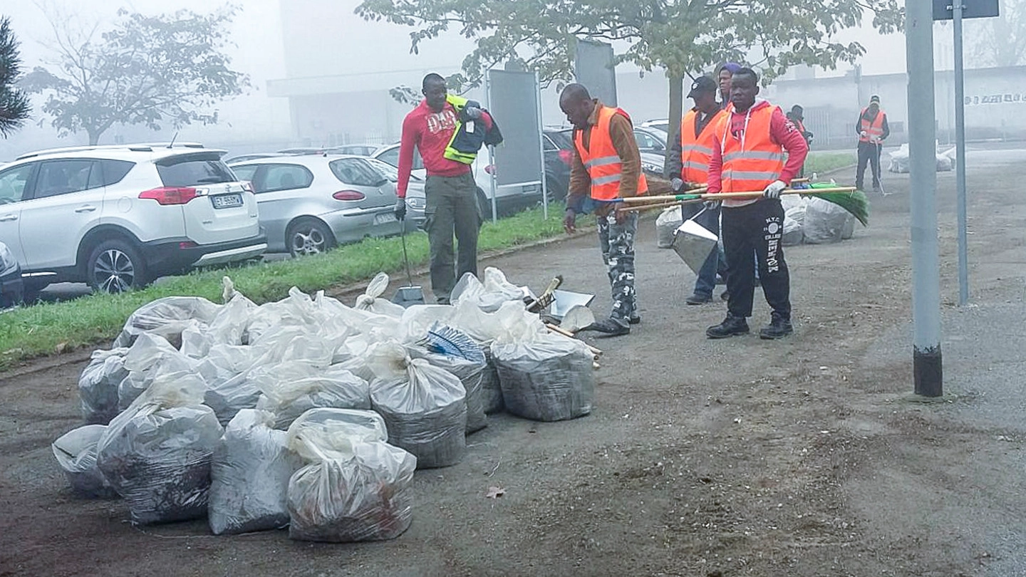 I migranti al lavoro raccolgono i rifiuti