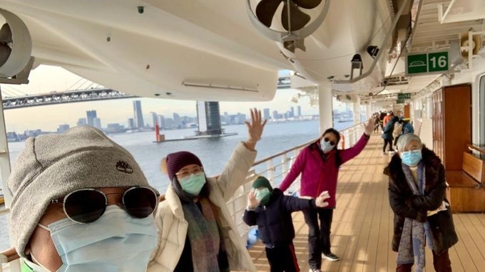 Yardley Wong sul ponte della nave, con la sua famiglia