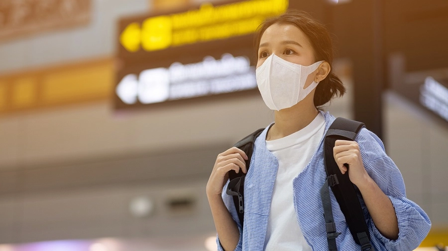 Una giovane in aeroporto con la mascherina
