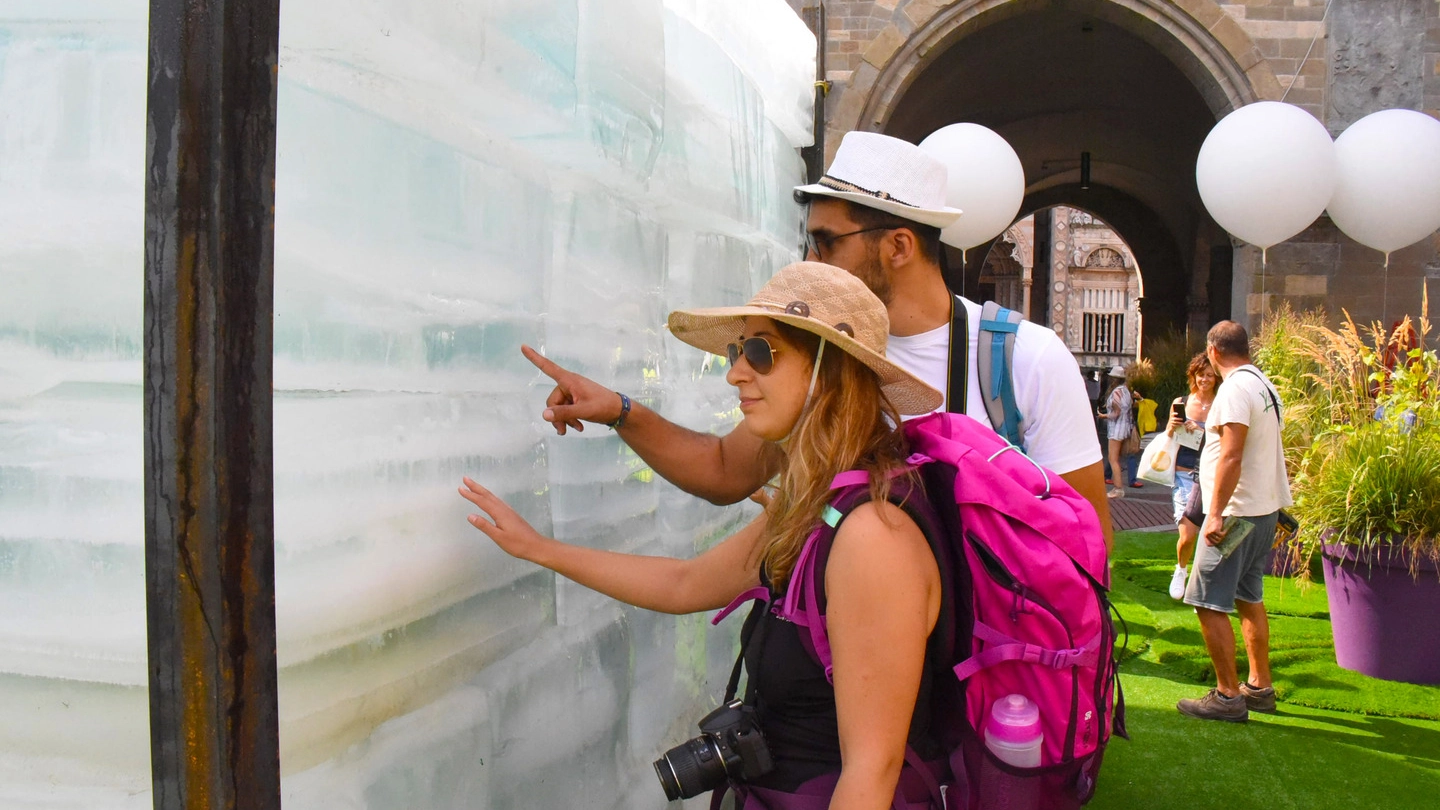 Due turisti davanti al blocco di ghiaccio