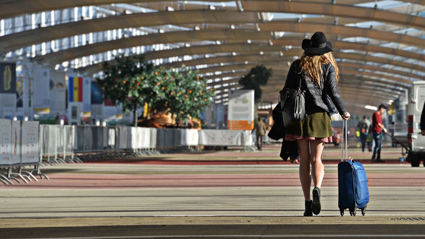 Iniziati i lavori di smantellamento a Expo, una ragazza solitaria con il trolley