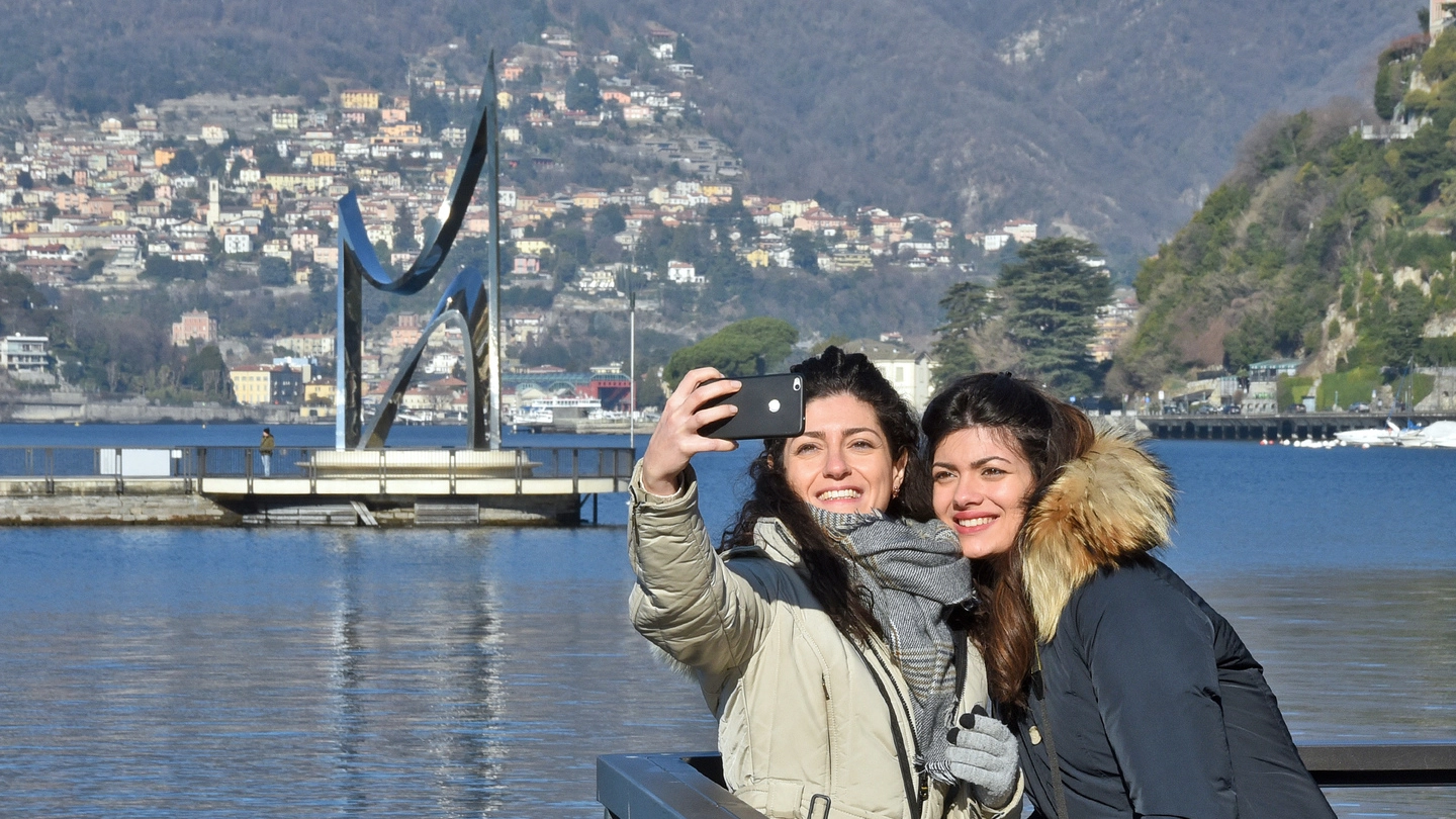 Turisti sul lago di Como. Sullo sfondo l’opera di Libeskind