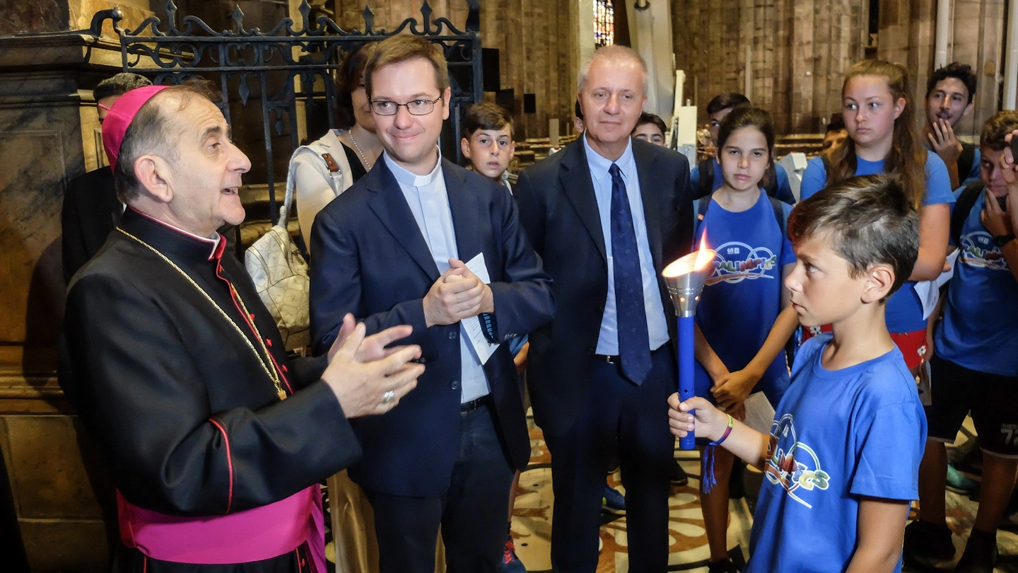 L'arcivescovo Mario Delpini consegna la fiamma olimpica ai ragazzi