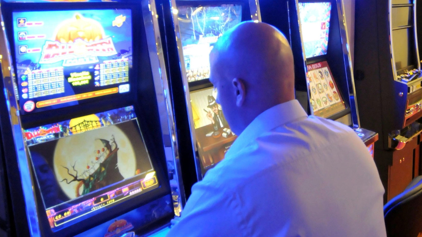 Un giocatore alle slot machine Un giocatore alle slot machine