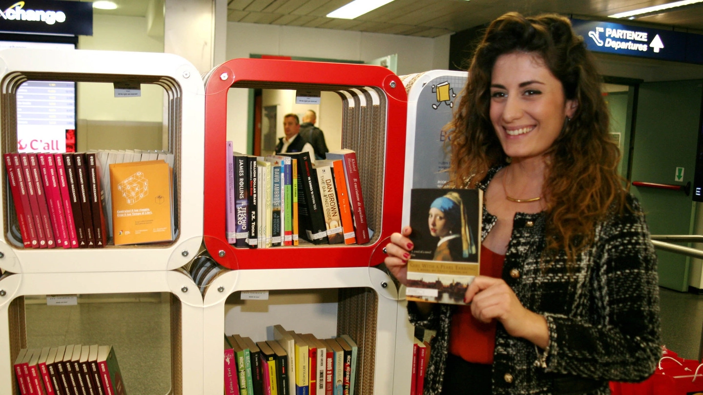 Una ragazza sceglie un libro a Linate