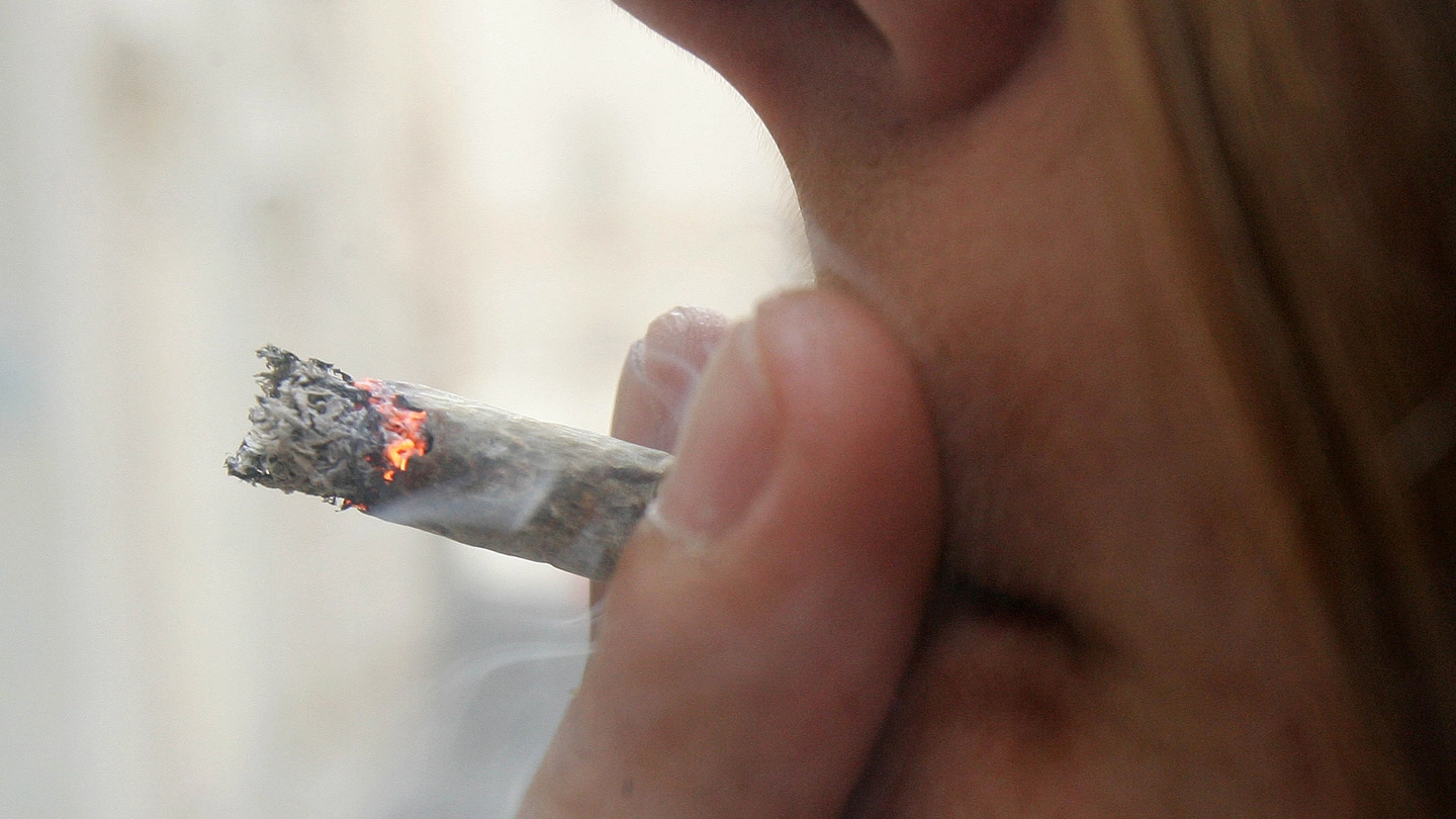 Un giovane mentre fuma uno spinello (foto d’archivio Ansa)