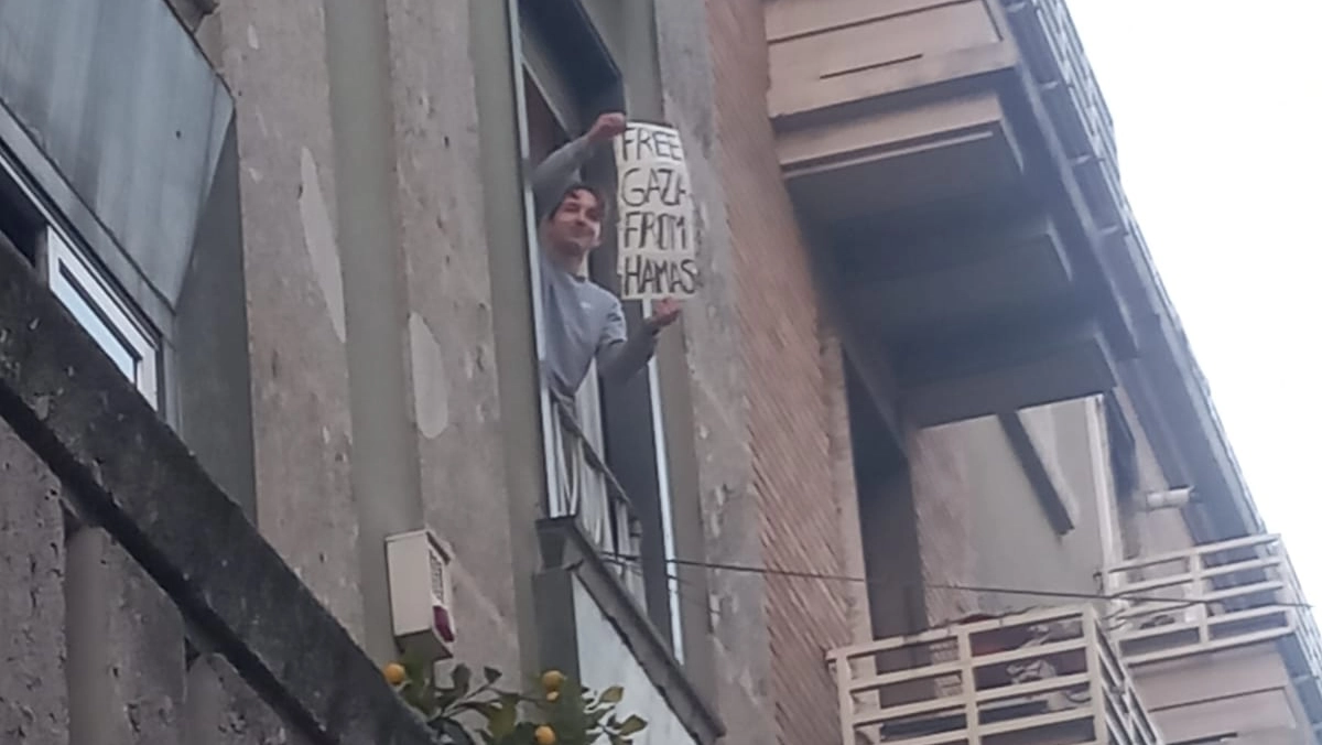 Un  residente di via Padova espone il cartello "Free Gaza from Hamas", Liberate Gaza da Hamas