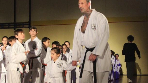 Mauro Genocchio porta per mano una piccola allieva all’inizio del suo percorso nel karate