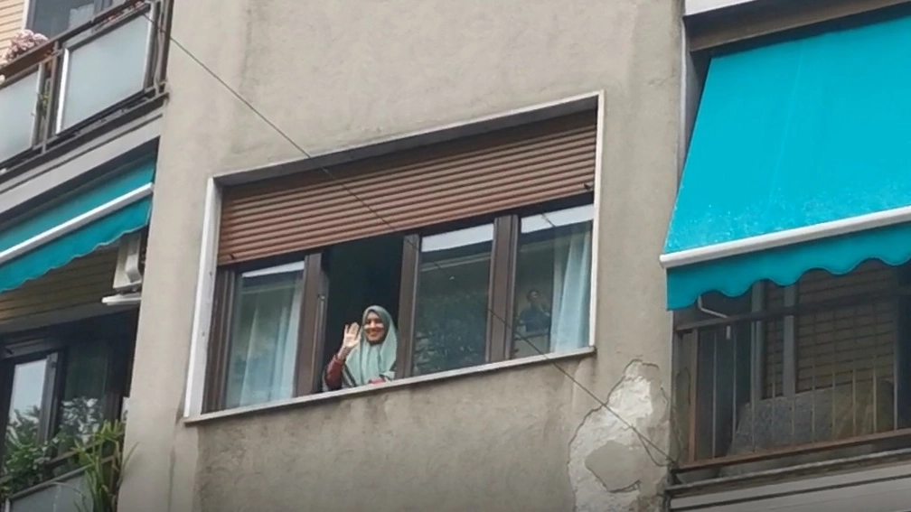 Silvia Romano saluta dalla finestra della sua abitazione (Foto Mianews)
