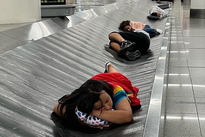 Passeggeri esausti si riposano sul nastro trasportatore