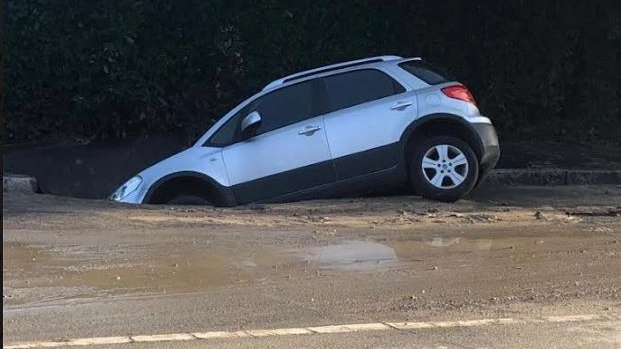 L'auto inghittita dalla voragine