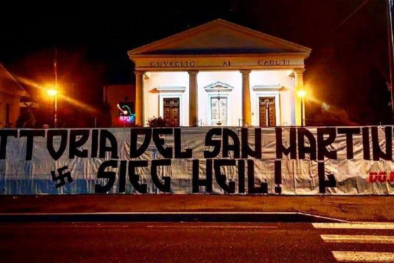 Lo striscione decorato con una svastica e la scritta "Sieg Heil" davanti al sacrario dei Caduti partigiani a San Martino