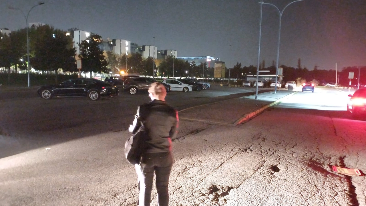 Assago, il parcheggio al buio illuminato solo dai fari di un'auto Assago, il parcheggio al buio illuminato solo dai fari di un'auto