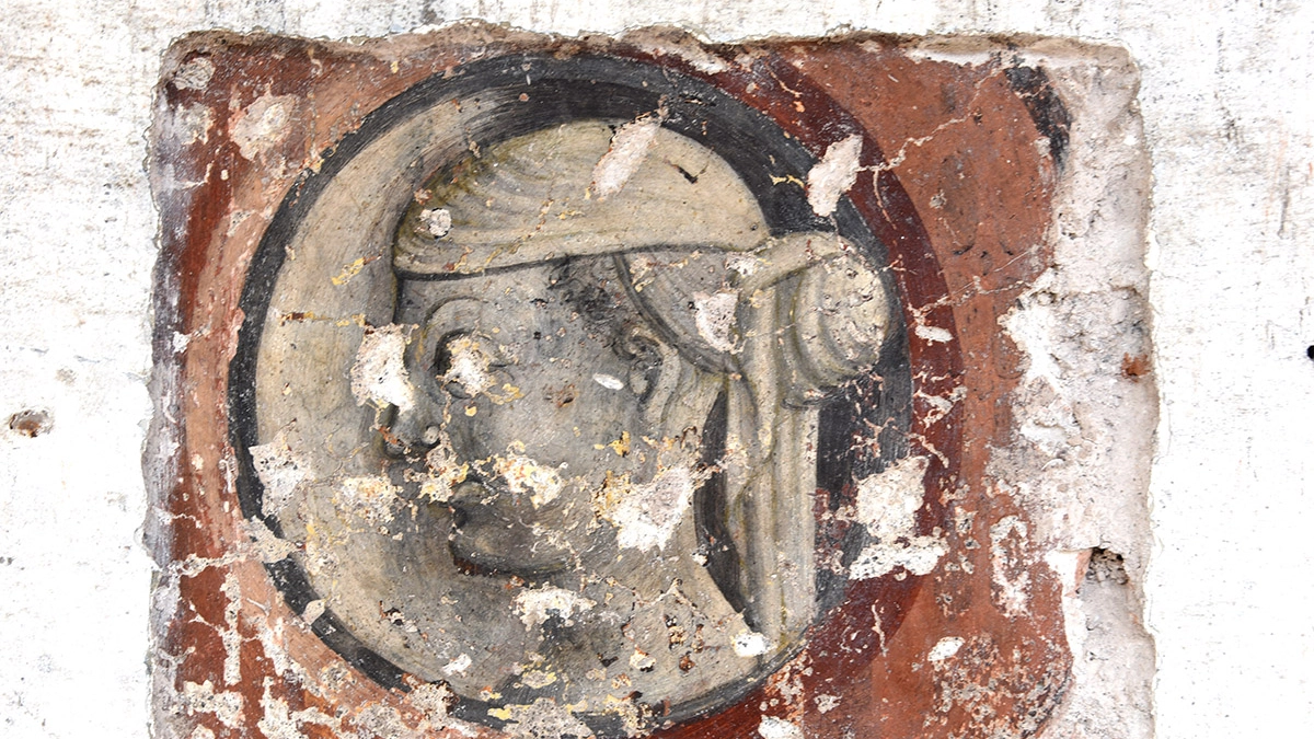 La testa quattrocentesca che sta comparendo sulla facciata di Palazzo Baga a Lavenone