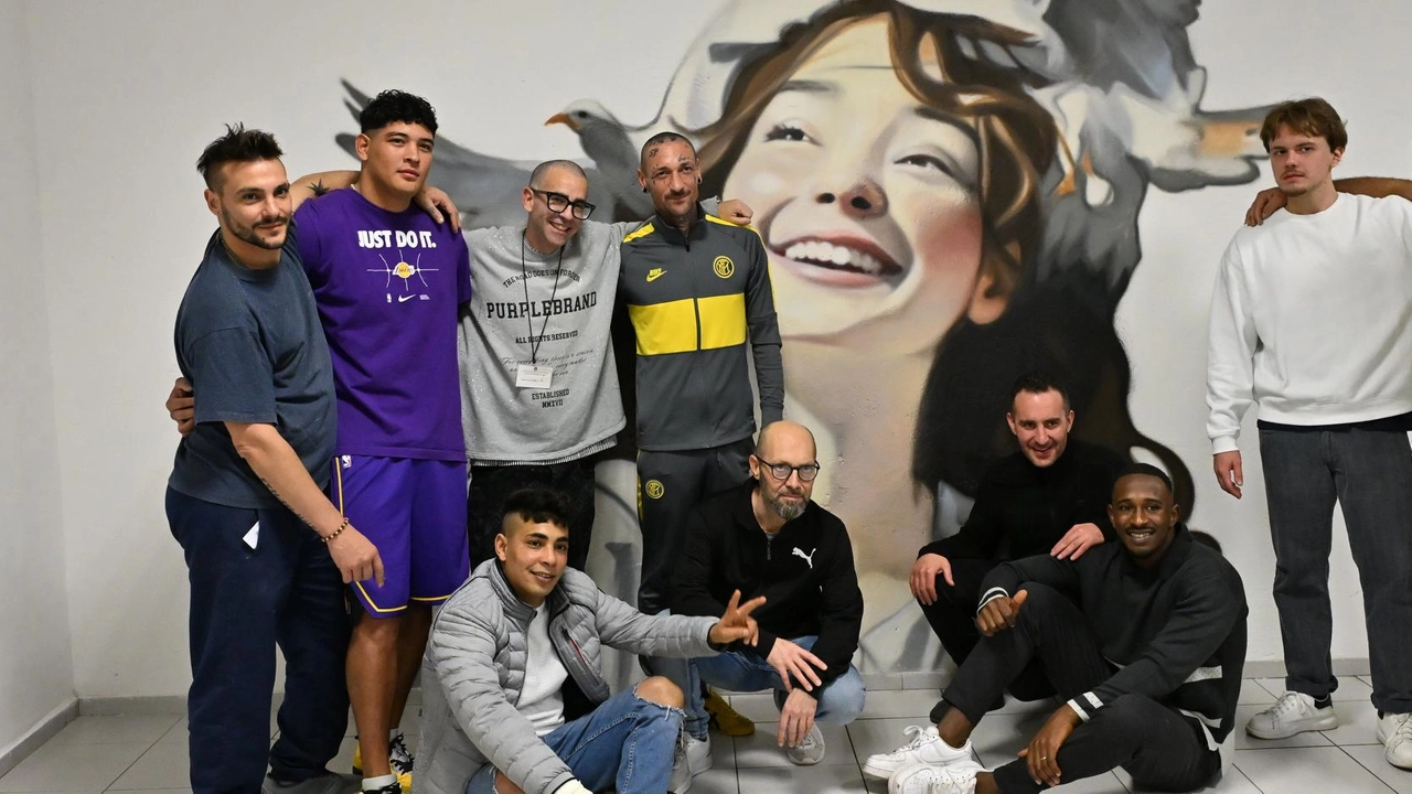 L’artista Andrea Ravo Mattoni insieme ad alcuni ospiti del carcere di Varese di fronte al murale realizzato nella sala colloqui L’artista Andrea Ravo Mattoni insieme ad alcuni ospiti del carcere di Varese di fronte al murale realizzato nella sala colloqui