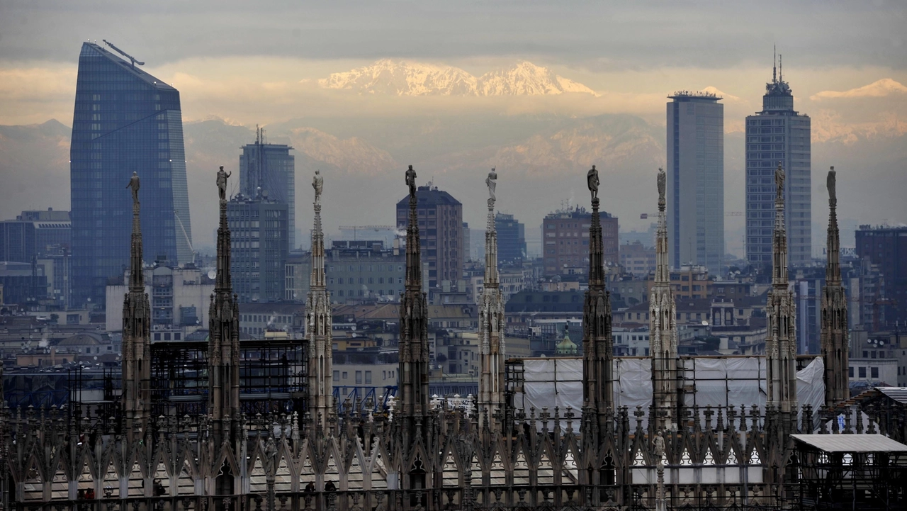Lo skyline di Milano con in primo piano le guglie del Duomo, la torre Diamante e il grattacielo Pirelli e sullo sfondo le Alpi Lo skyline di Milano con in primo piano le guglie del Duomo, la torre Diamante e il grattacielo Pirelli e sullo sfondo le Alpi