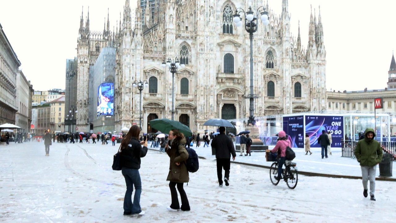 Sopra, Piazza Duomo imbiancata. Sotto, un uomo cammina sotto la “nevicata“ Sopra, Piazza Duomo imbiancata. Sotto, un uomo cammina sotto la “nevicata“
