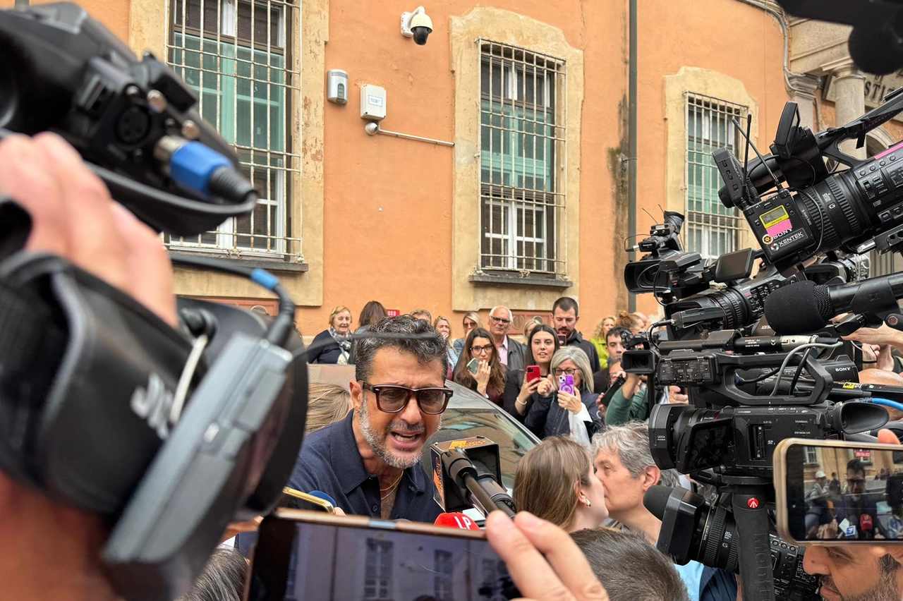 Fabrizio Corona assediato dai cronisti fuori dal tribunale di Pavia
