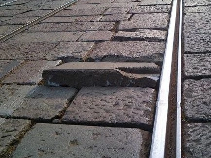 Un massello del pavé semi-divelto vicino a un binario del tram, simile a quello che probabilmente ha causato l'incidente in via Rubens