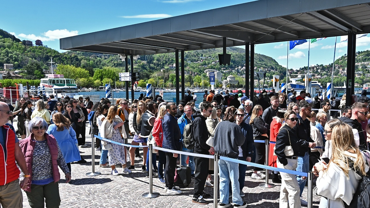 Turisti aspettano i traghetti sul lungolago di Como
