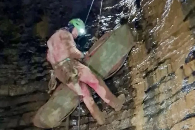 La barella col corpo della speleologa viene condotta fuori dalla grotta