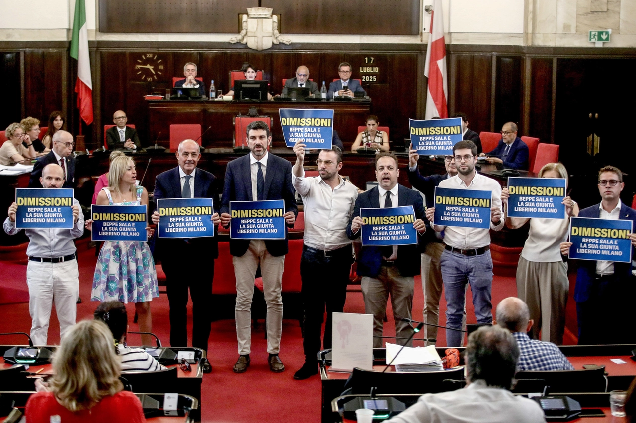 Raadsleden van de oppositie protesteren met spandoeken tijdens de gemeenteraadsvergadering naar aanleiding van het stedenbouwkundig onderzoek in Palazzo Marino in Milaan.