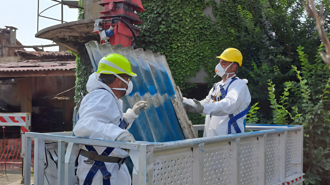 Operai al lavoro per rimuovere le coperture di eternit (cemento e amianto) dal tetto della Cascina Moretti Operai al lavoro per rimuovere le coperture di eternit (cemento e amianto) dal tetto della Cascina Moretti