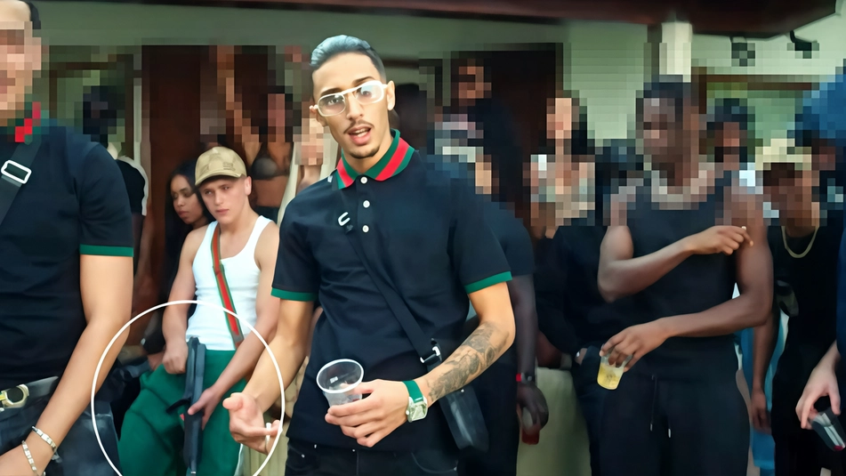 Un frame del video: al centro il trapper Baby Gang, nel cerchio una delle armi