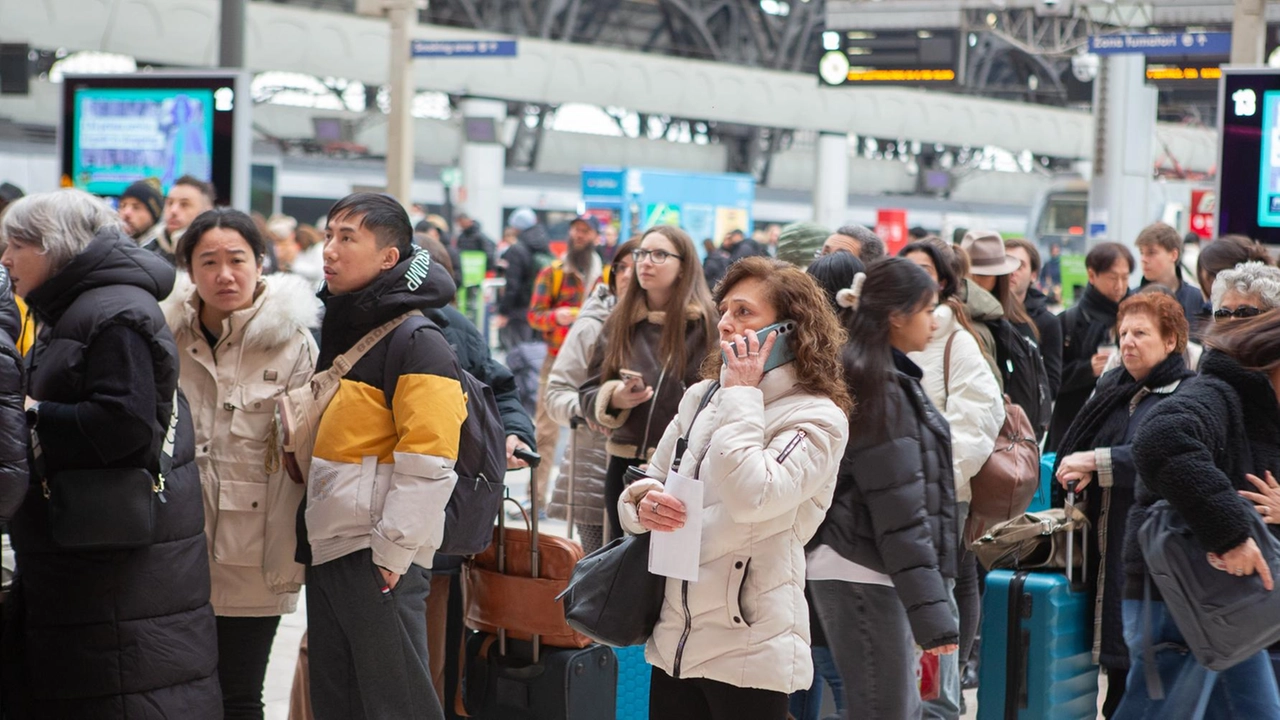 Viaggiatori in Stazione Centrale davanti al tabellone delle partenze Viaggiatori in Stazione Centrale davanti al tabellone delle partenze