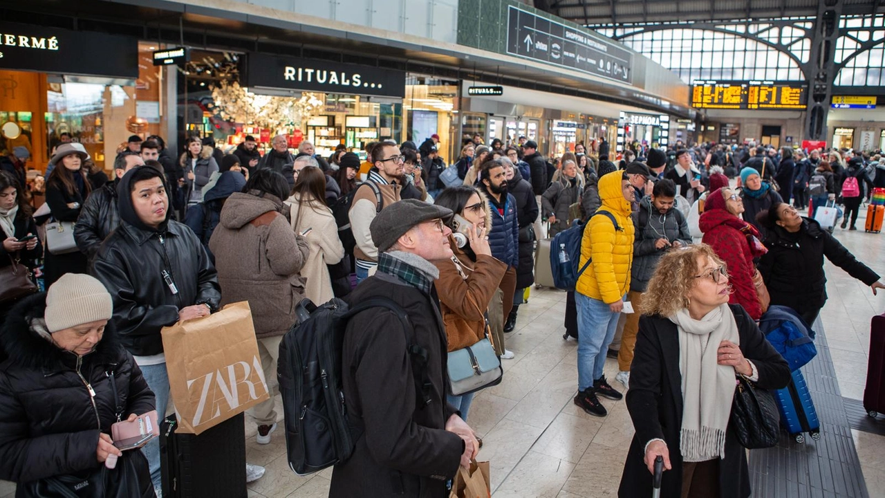 Viaggiatori guardano sconsolati un tabellone delle partenze alla stazione Centrale Viaggiatori guardano sconsolati un tabellone delle partenze alla stazione Centrale