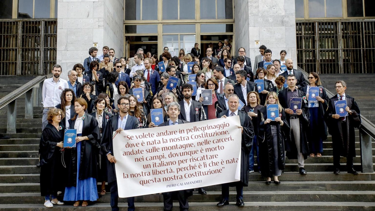Uno striscione con una frase del giurista e politico Pietro Calamandrei, in mano una copia della Costituzione italiana. Decine di...
