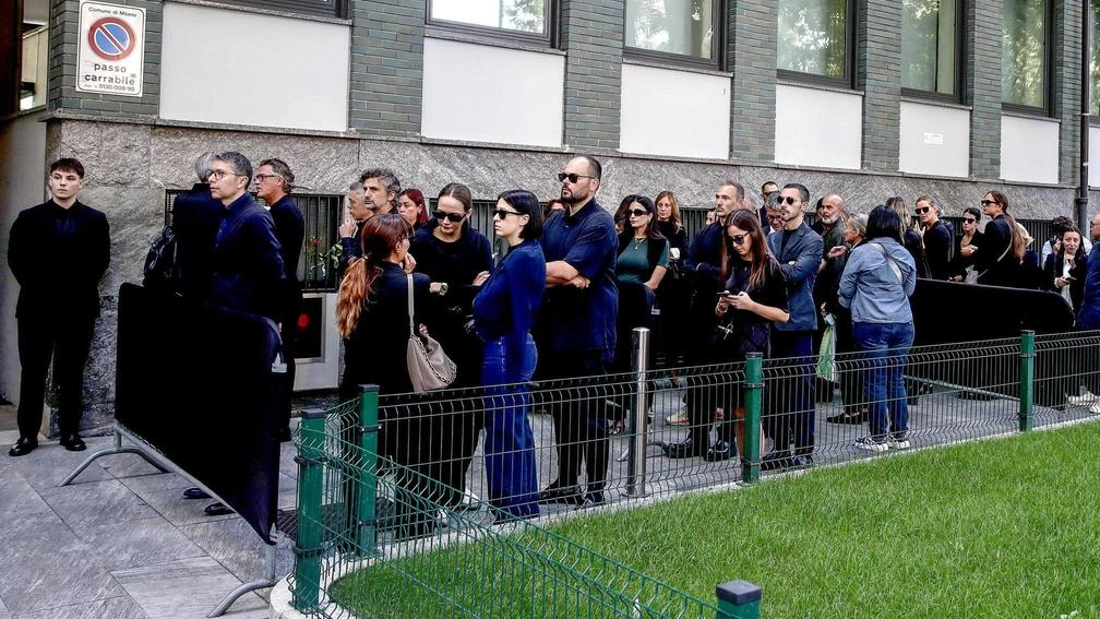 Omaggio di vip, dipendenti e cittadini. Lanterne e rose bianche per lo stilista. .
