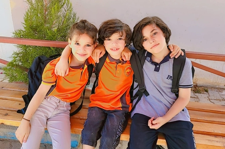 Shahame, 10 anni, assieme ai suoi due fratellini. Tutti e tre vivono nel campo profughi turco di Rehianly. Grazie all'adozione a distanza tutti e tre possono andare a scuola