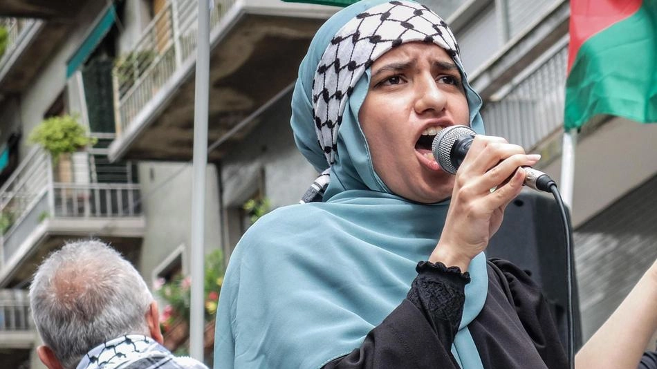 Una manifestante Pro Pal parla per strada al microfono durante uno dei cortei milanesi Una manifestante Pro Pal parla per strada al microfono durante uno dei cortei milanesi