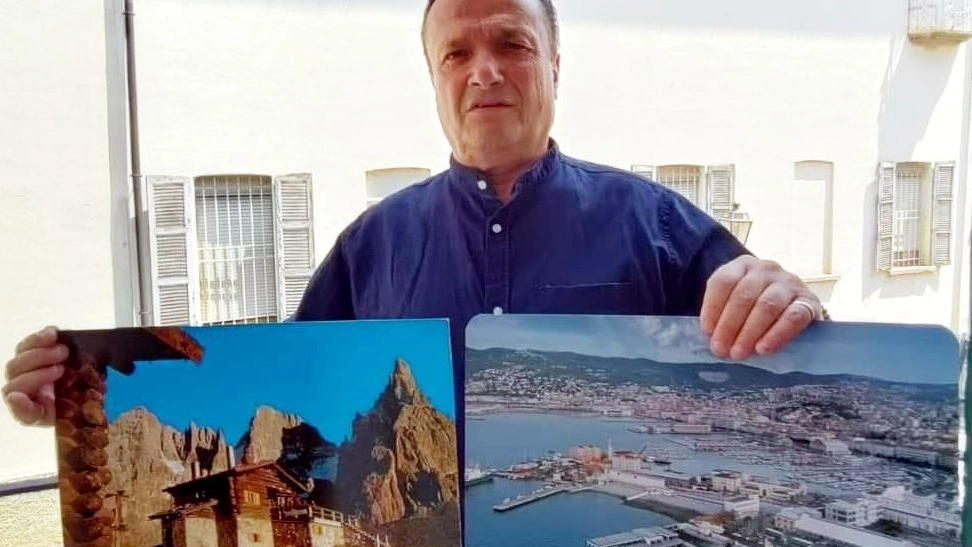 Alessio Fumagalli con due (grandi) cartoline della sua collezione: alcune stampe sono molto rare e preziose, veri e propri pezzi di antiquariato