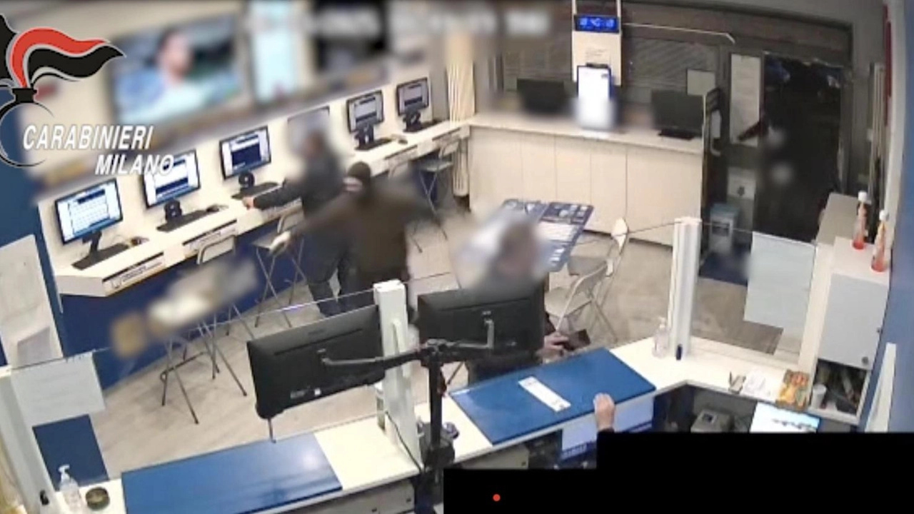 Un fotogramma ripreso dalla telecamera interna: i rapinatori minacciano il gestore della sala