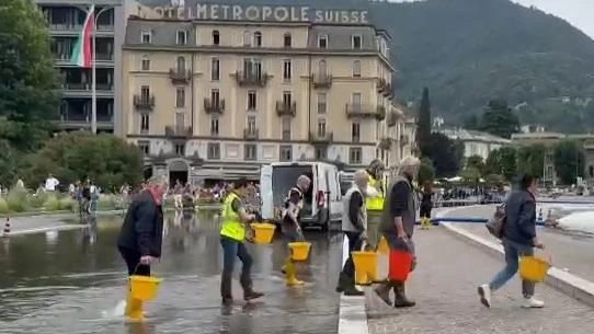 I sindaci dei paesi lungo la Lariana per alcuni minuti hanno inscenato la loro protesta raccogliendo l’acqua fuoriuscita in piazza per ributtarla nel lago